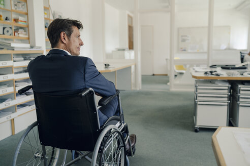 Disabled businessman sitting in wheelchair - GUSF01013