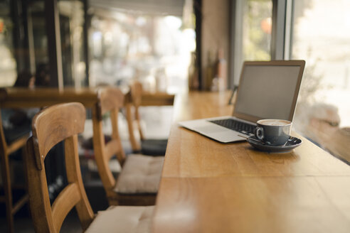 Laptop with blank screen in coffee shop - GUSF01014