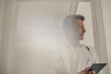 Doctor standing in hospital, using digital tablet - GUSF01079