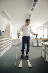 Geschäftsmann beim Skifahren im Büro - GUSF01084