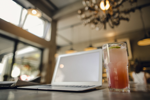 Laptop mit leerem Bildschirm in einem Kaffeehaus, lizenzfreies Stockfoto