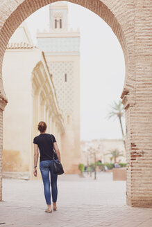 Marokko, Marrakesch, Rückenansicht einer Frau mit Blick auf die Kasbah-Moschee - MMAF00486