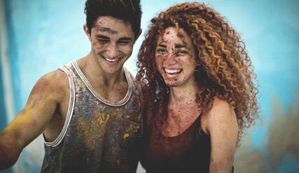 Two people covered in paint splatter and smiling. - MINF08612