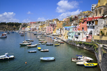 Harbor with moored boats, and colourful waterfront buildings on the hillside overlooking the waterfront. Procida, in the Flegrean Islands off the coast of Naples. - MINF08627