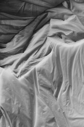 Schwarz-Weiß-Nahaufnahme von zerknitterten Baumwolllaken auf dem Bett. - MINF08662