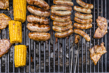 Different meat, maize and fried sausages on barbecue grill - TCF05635