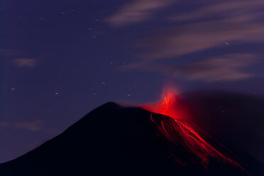 Abendlicher Blick auf einen feurigen Vulkanausbruch, bei dem Lava die Berghänge hinunterläuft. - MINF08793