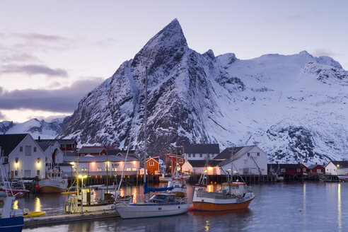 Im Hafen der Siedlung liegen Fischerboote vor dem Hintergrund schneebedeckter Berge. - MINF08796