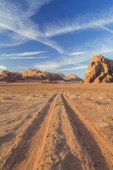 Desert landscape with tire tracks leading to distant mountain. - MINF08824
