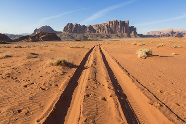 Desert landscape with tire tracks leading to distant mountain. - MINF08827