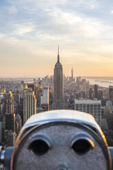 Cityscape of Manhattan, New York, USA, at dusk, with illuminated Empire State Building in the centre, coin operated binoculars in the foreground. - MINF08843