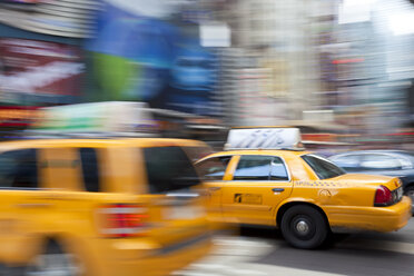 Yellow cabs driving on street near Times Square in Manhattan, New York, USA, motion blur. - MINF08895