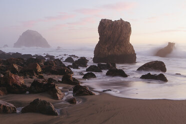 Seascape with breaking waves on rocks on sandy beach at dusk. - MINF08909