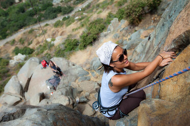 Asiatisch-amerikanische Frau beim Klettern an einer Granitfelswand. - AURF00562