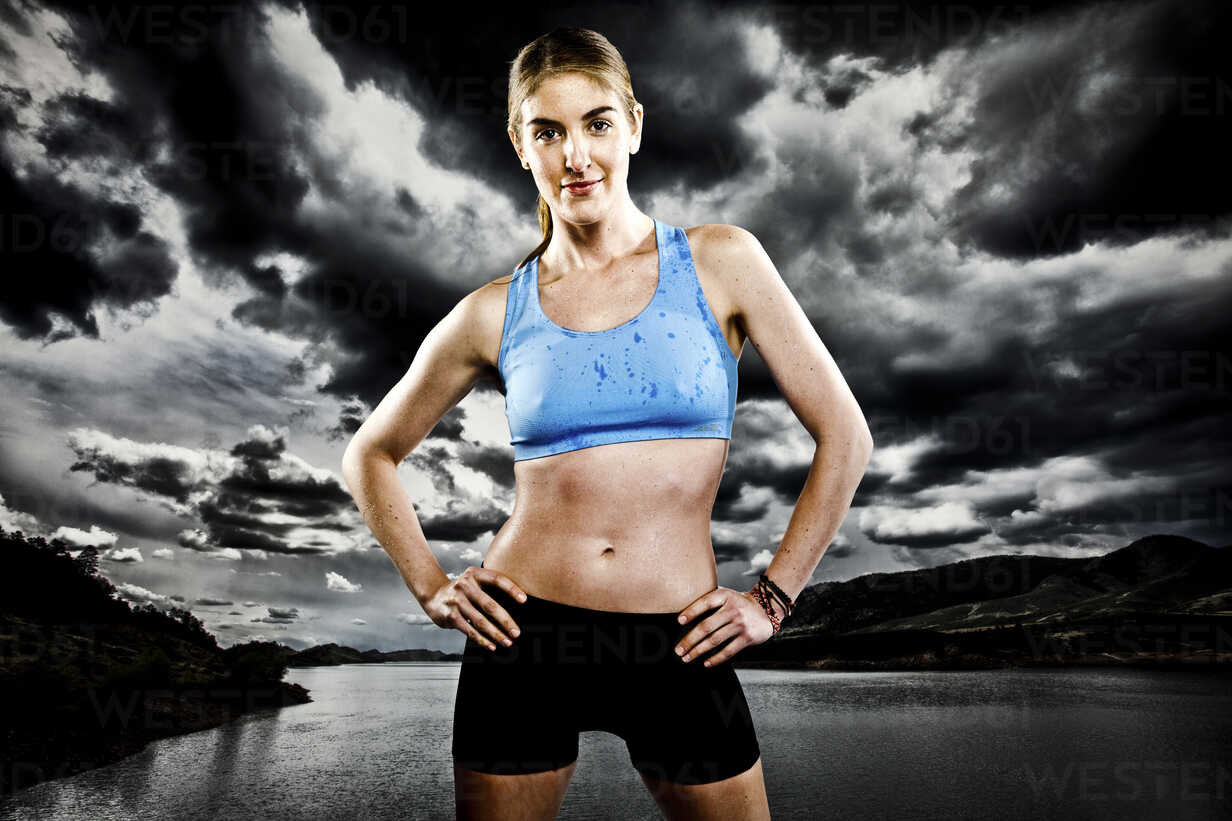 An athletic woman poses while running with a blue sports bra and
