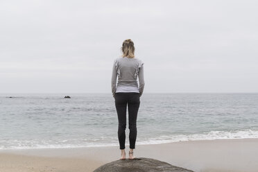 Rückenansicht einer Frau, die am Strand steht und in die Ferne schaut - CHPF00503