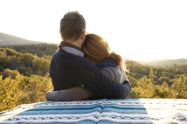 Couple watch the sunset and hug on the side of the road. - AURF00592