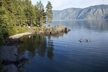 Friends kayak next to the camping site on a lake in Idaho. - AURF00634