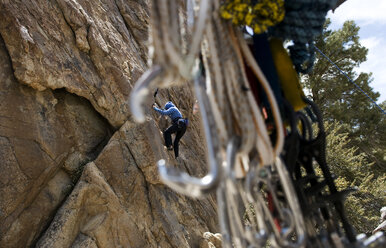 Eine junge Frau, die sich langsam in die Saison einarbeitet, wärmt ihre Klettermuskeln bei ihrer ersten Klettertour in Benton, Kalifornien, auf. - AURF00639