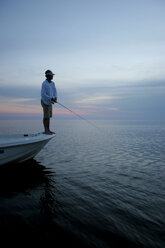 Silhouette eines Fischers von seinem Boot aus in der Abenddämmerung im Golf von Mexiko. - AURF00648