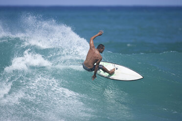 A young man surfing at Rocky Point on the North Shore of Oahu, Hawaii. - AURF00676