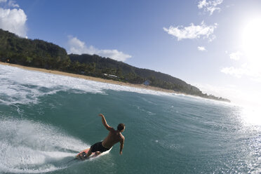 A young man surfing past the camera at Pupukea, on the north shore of Oahu, Hawaii. - AURF00679