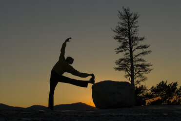 Eine junge Frau macht Yoga im Abendlicht. - AURF00702