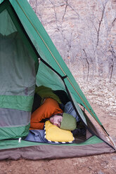 Ein junger Mann schläft in einem offenen Zelt, Moab, UT. - AURF00710