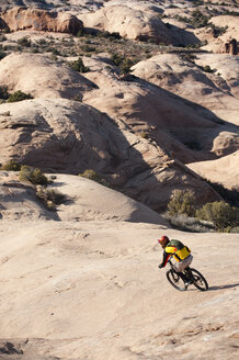 Ein junger Mann fährt mit seinem Mountainbike auf dem Slickrock Trail, Moab, UT. - AURF00712