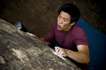Ein junger Mann klettert ein Boulderproblem in der Painted Cave, Santa Barbara, CA. - AURF00713