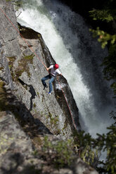 Ein junger Mann seilt sich neben einem Wasserfall in Idaho von einer Klippe ab. - AURF00728