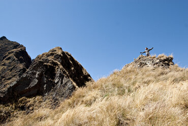 Ein junger Mann blickt in die Ferne, während er auf dem Gipfel des Dead Woman's Pass, Inca Trail, nachdenkt. - AURF00733