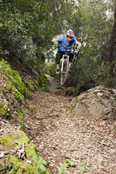 Ein junger Mann fährt mit seinem Downhill-Mountainbike auf dem Knapps Castle Trail, umgeben von einer wunderschönen Landschaft in Santa Barbara, CA. - AURF00740