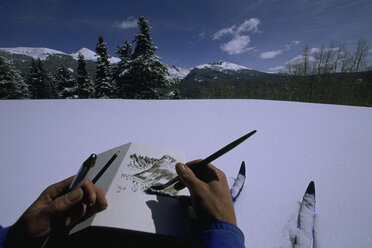 An artist makes a sketch in the backcountry of the Rocky Mountains. - AURF00763