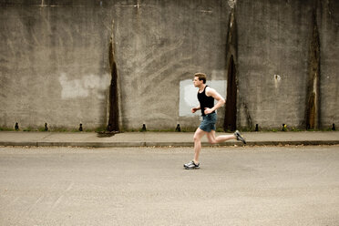 Ein sportlicher Mann joggt an einer Betonmauer in Portland, Oregon, vorbei. - AURF00804