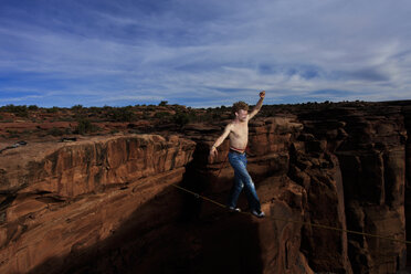 Andy Lewis läuft über eine Highline in einem Swammy Belt in der Fruit Bowl in Moab, Utah, USA. - AURF00832