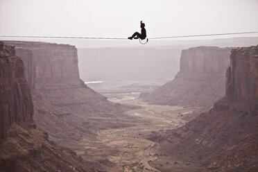 Andy Lewis bei der Arbeit an einer dreihundertvierzig Fuß langen Weltrekord-Highline in der Fruit Bowl in Moab, Utah, USA. - AURF00835