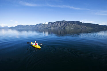 An adventurous retired man kayaking across a huge calm lake in Idaho. - AURF00844