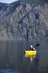 An adventurous retired man kayaking across a huge calm lake in Idaho. - AURF00846