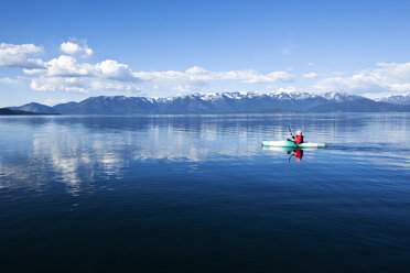 Eine abenteuerlustige Frau fährt mit dem Kajak über einen großen, ruhigen See in Idaho. - AURF00847