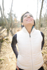 Eine sportliche Frau dehnt sich vor einem Lauf im Winter im Wald. - AURF00849