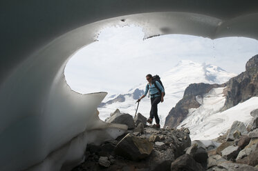 A mountaineering woman passing a glacial terminus, Mount Baker Wilderness, Bellingham, Washington. - AURF00872