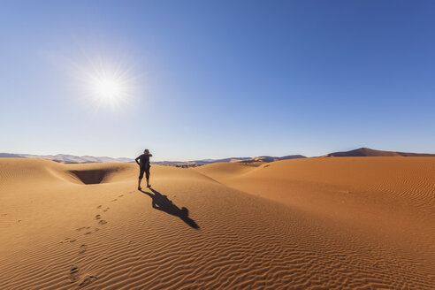 Afrika, Namibia, Namib-Wüste, Naukluft-Nationalpark, Touristin geht auf Düne - FOF10069