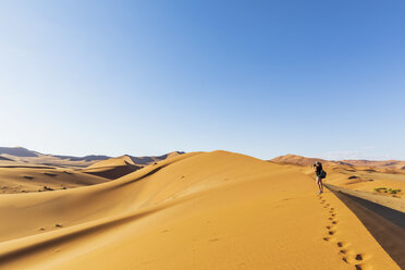 Afrika, Namibia, Namib-Wüste, Naukluft-Nationalpark, Touristin geht auf Düne - FOF10077