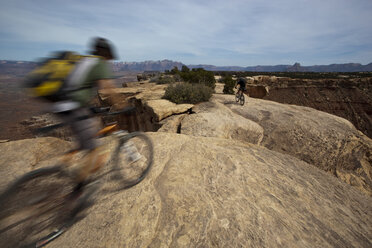 Zwei Personen fahren mit dem Mountainbike einen Felsen in der Nähe von Hurricane, Utah, hinunter. - AURF00925