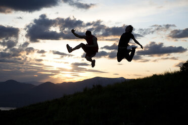 Two men jumping at sunset in Idaho. - AURF00955