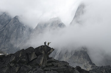 Zwei Wanderer auf einer Felsspitze in den nebligen Bergen, Bugaboo Provincial Park, Radium, British Columbia, Kanada. - AURF00975