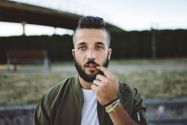 Porträt eines jungen Mannes mit Finger auf dem Mund - RAEF02112