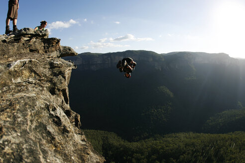 Ein BASE-Springer vollführt einen Frontflip von einer Klippe in den Blue Mountains, New South Wales, Australien. - AURF00990