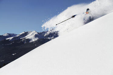 A athletic skier rips fresh powder turns on a sunny day in Colorado. - AURF00999